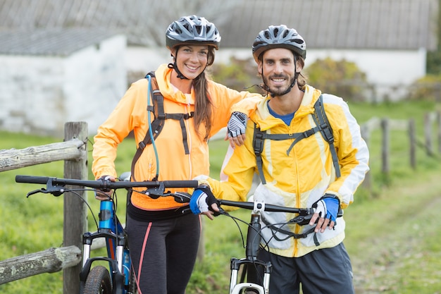 Biker couple with mountain bike in countryside