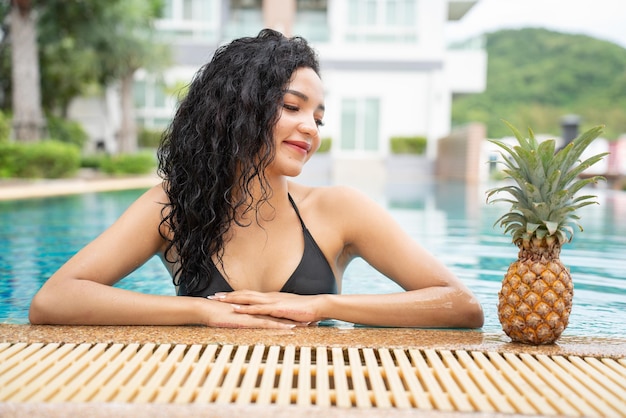 Bikini young woman showing pineapple Pineapple fruit woman smiling healthy and joyful Mixedrace Asian Caucasian model with pineapple