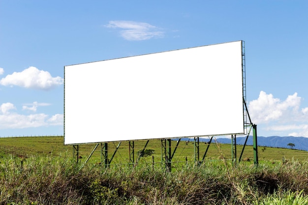 Billboard on the road. green grass and blue sky composing the landscape