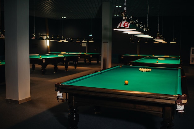 Billiard table with green surface and balls in the billiard club