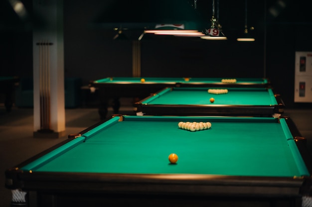 Billiard table with green surface and balls in the billiard club.