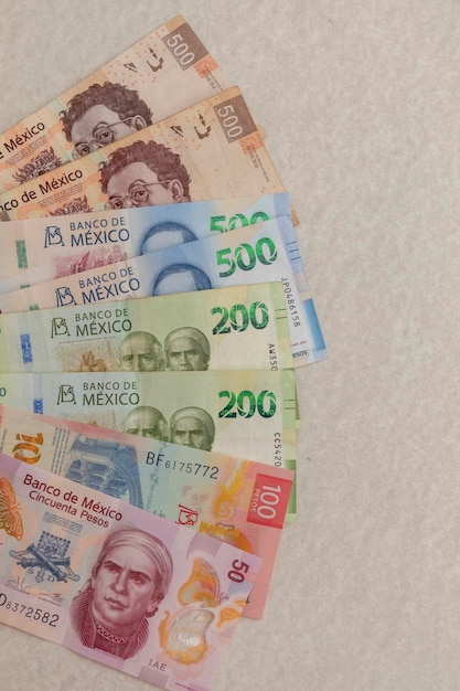 Bills of different denominations of Mexican pesos on a table