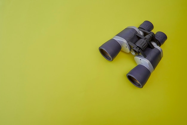 Binoculars silver and gray on yellow background