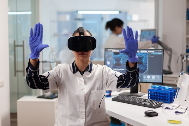 Photo biochemist doctor experiencing virtual reality wearing headset during vaccine experiment