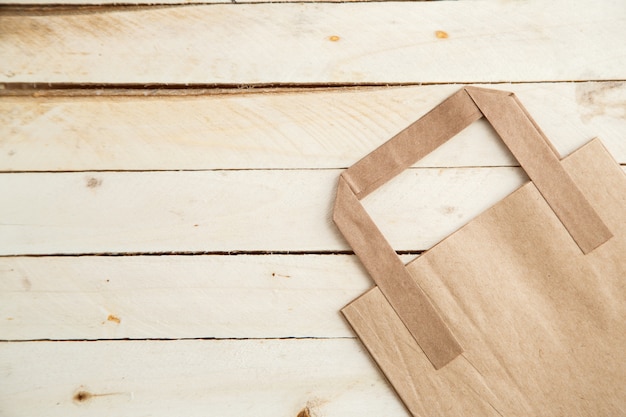 Biodegradable environmentally friendly cardboard bag on wooden background