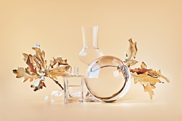 Biophilic Autumn background Gilded gold maple leaves distorted by transparent glass jars small bottles Monocholored orange beige floral elements with reflections