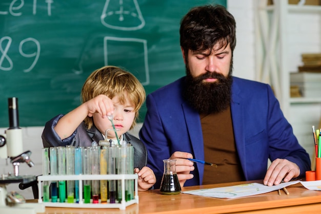 Biotechnology research concept Wisdom Back to school Formula experiments in organic chemistry laboratory small boy with teacher man son and father at school Education teaches us way of living