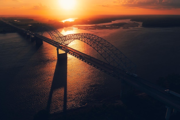 Bird's eye view of Memphis Bridge connecting Tennessee and Arkansas at sunset over Mississippi River