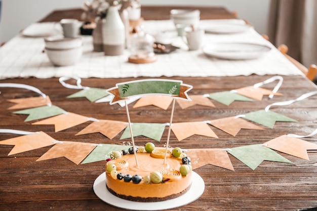 The birthday cake stands on a table decorated with flags and decor