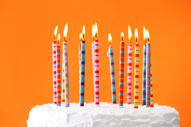 Birthday cake with candles on color background