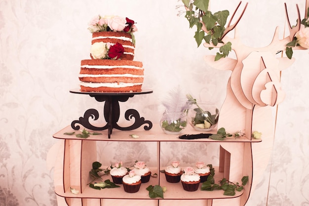 Birthday cake with cupcakes and decoration on tray in room close up. Celebration