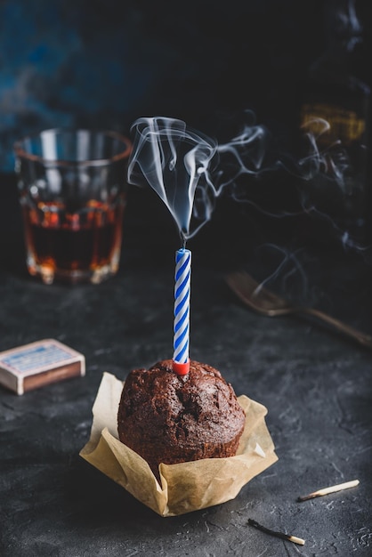 Birthday chocolate muffin with smoking candle