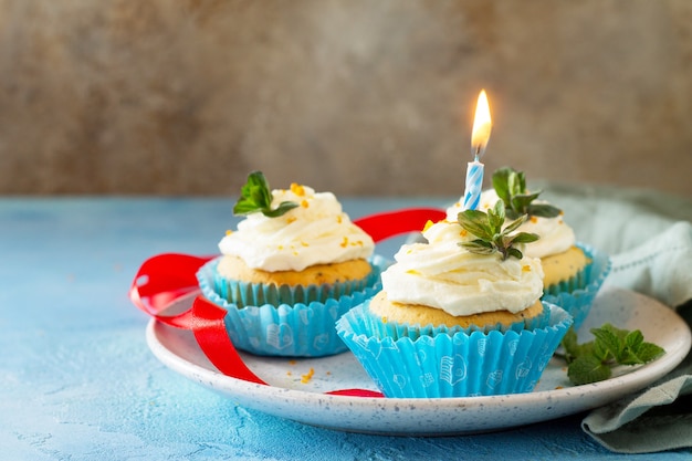 Birthday cupcake with whipped cream poppy and orange peel Copy space