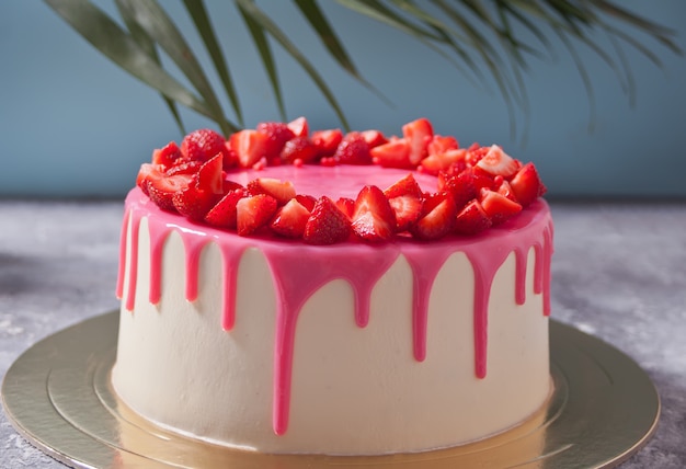 Birthday delicious cake with pink glaze decorated fresh strawberries.