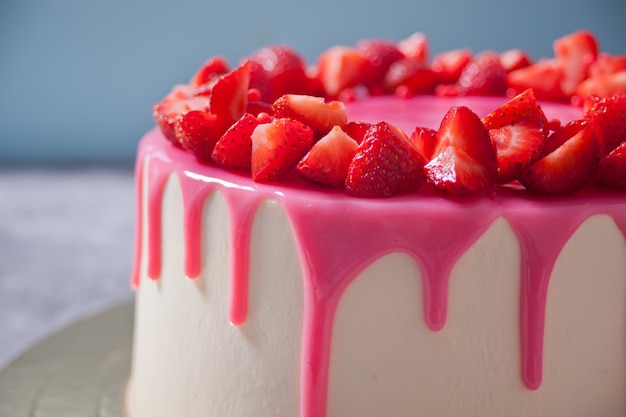 Birthday delicious cake with pink glaze decorated fresh strawberries.