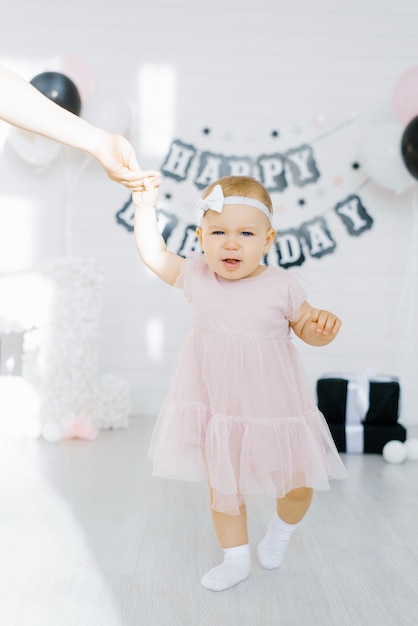 Birthday girl 1 year holds her mother's hand and is indignant, not happy