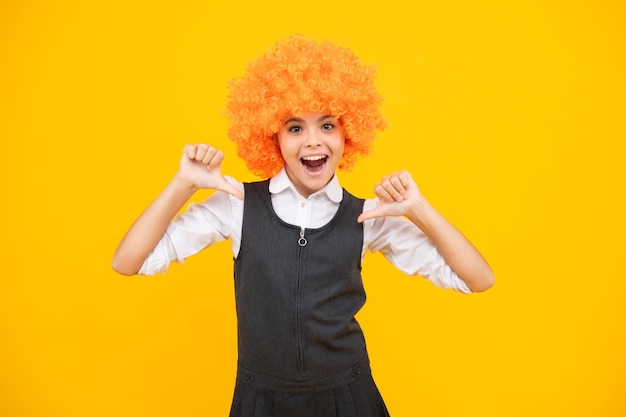 Birthday kids party Funny kid in curly clown wig isolated on yellow background Excited face cheerful emotions of teenager girl