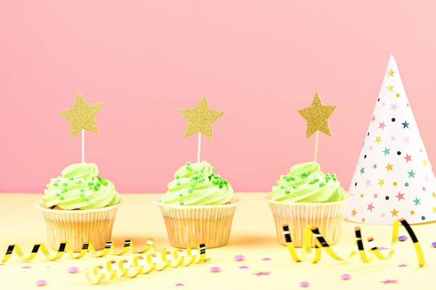 Birthday party accessories and event supplies background with sweets cupcakes confetti balloons party hats decorations copy space