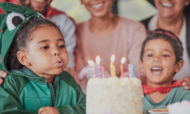 Birthday party and happy family with girl and candle on cake for celebration gift and announcement Wow support and costume with children and parents at home for surprise event and dessert