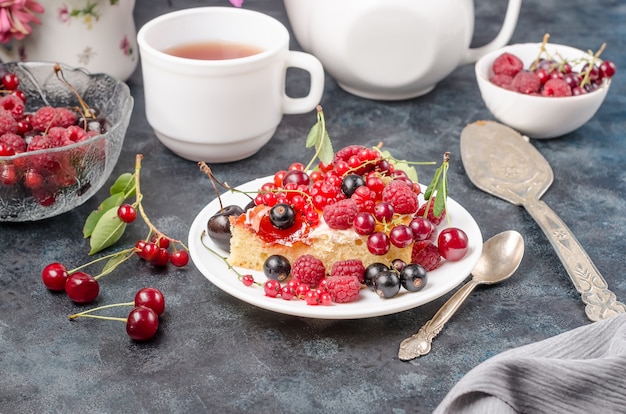 Biscuit cake with summer berries on a black background