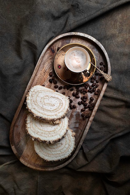 Biscuit roll with cups of black coffee on a textile draped table