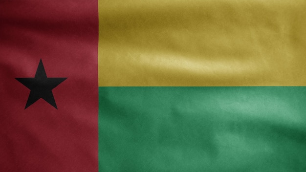 Bissau Guinean flag waving in the wind. Close up of Guinea Bisau banner blowing, soft and smooth silk. Cloth fabric texture ensign background.