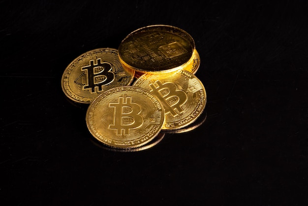 Bitcoin bitcoin coins placed on a dark reflective background selective focus