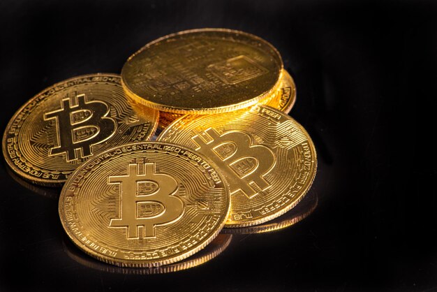 Bitcoin bitcoin coins placed on a dark reflective background selective focus