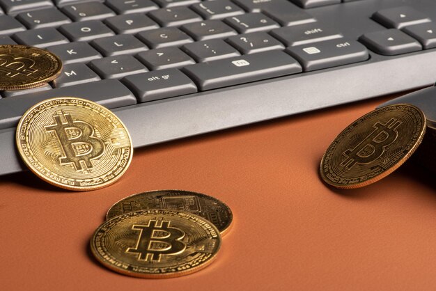 Bitcoin bitcoin coins with a computer keyboard and mouse placed on a dark background selective focus