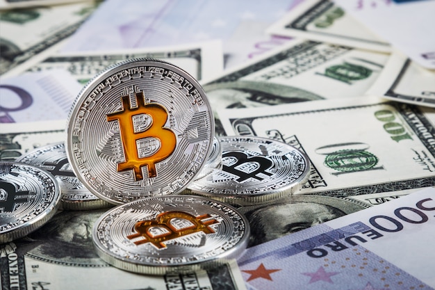 Bitcoin coins on background of banknotes of dollars and euros