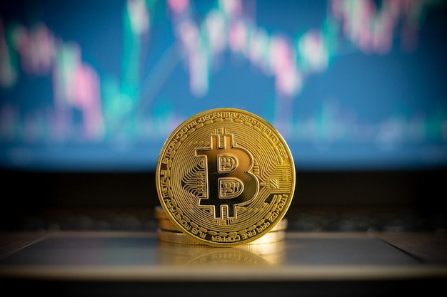 Bitcoin cryptocurrency coin and financial chart in background