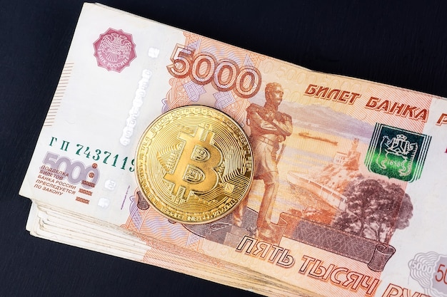 Bitcoin cryptocurrency with russian rubles money, five thousand banknotes closeup