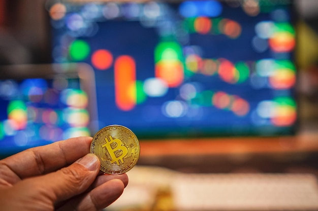 Bitcoin gold coins in the hands of a stockist with blurry chart background The concept of virtual currency