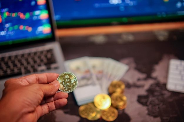 Bitcoin gold coins in the hands of a stockist with blurry chart background The concept of virtual currency