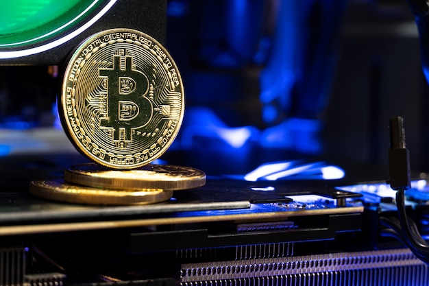 Bitcoin golden coins on a motherboard with neon light.