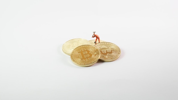 Bitcoin mining miniature worker on white background small figure holding mattock digging on More Bitcoin cryptocurrency coin