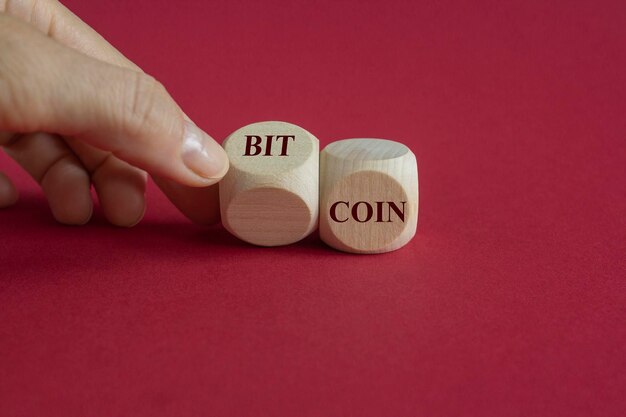 Bitcoin symbol Hand turns dice and changed the word coin to bitcoin Beautiful red background