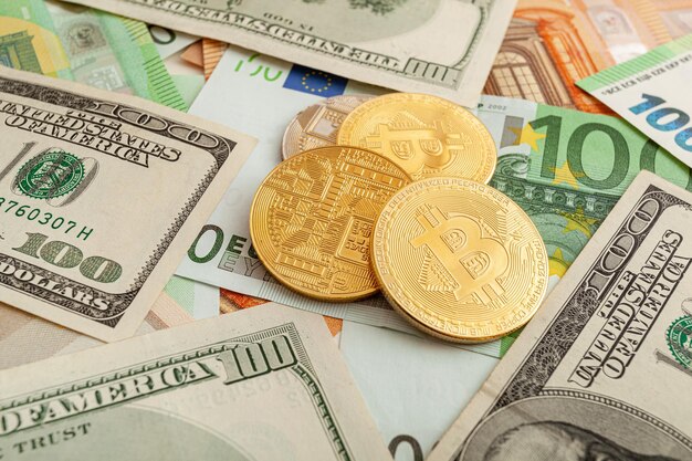 Bitcoins on a texture background of euro and dollars