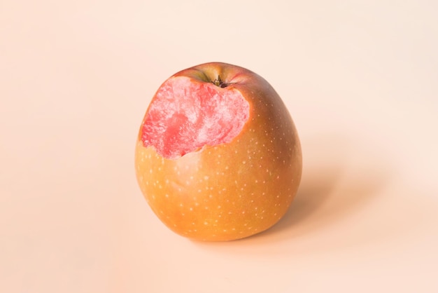 Bitten apple with red flesh inside on a yellow background Side view Nibbled Asia Crabapples