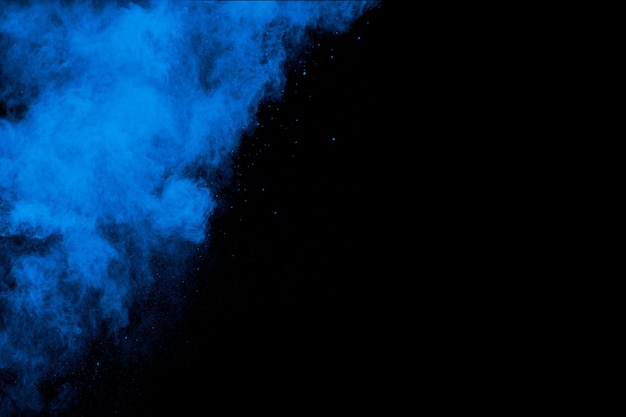 Bizarre forms of blue powder explosion cloud on white background.Launched blue dust particles splashing.