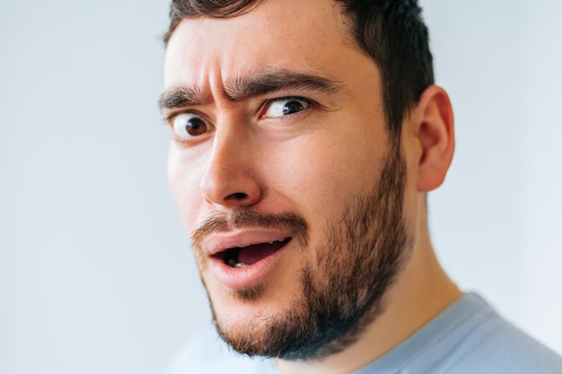 Bizarre and strange bearded man male face grimace looking at camera