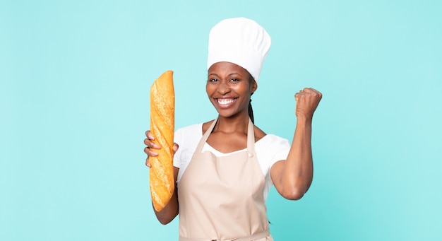 Black african american adult chef woman holding a bread baguette