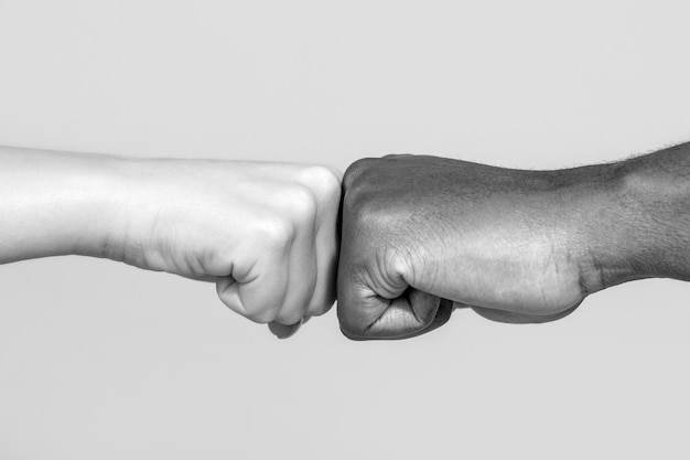 Black African American race male and woman hands giving a fist bump, multiracial diversity, immigration concept. Stop racism campaign. Closeup of multicultural friends giving fist bump to each other