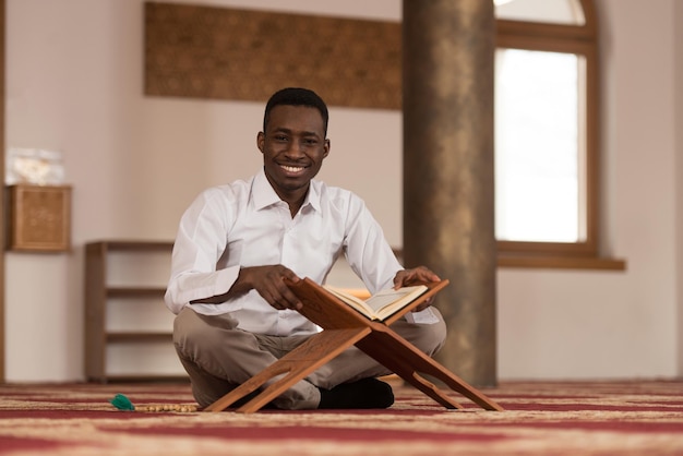 Black African Muslim Man Is Reading The Koran