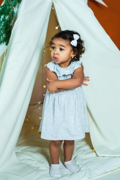 Black africanamerican girl play in a tent wigwam kid is sad and scared baby is alone and upset