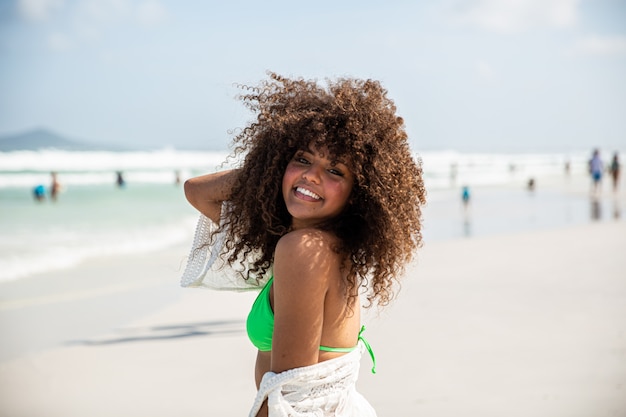 Black afro young cute girl, curly hair, bikini, beach. Afro American summer vacation holiday.