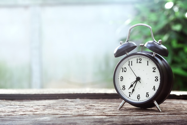 Black alarm clock classic on old wooden table