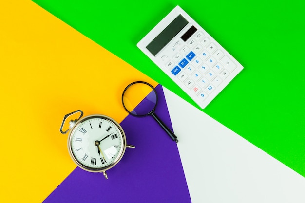 Black alarm clock on color block , office interior