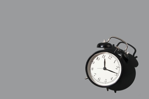 Black alarm clock on gray background