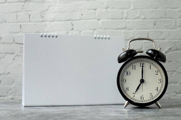 Black alarm clock with blank screen on calendar.